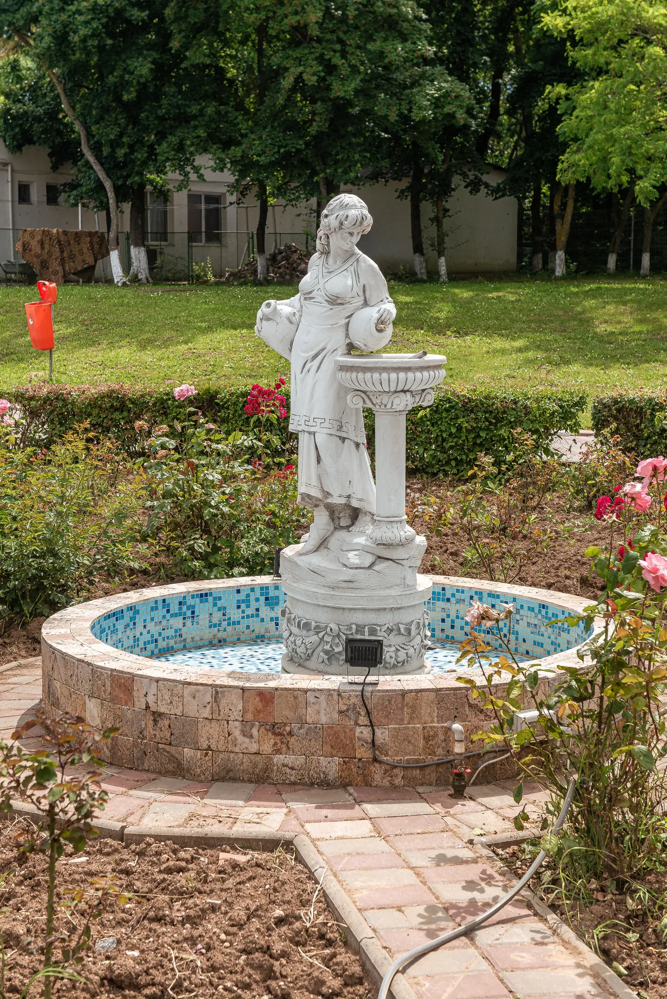 Fântâna decorativă cu statuie, în grădina cu trandafiri