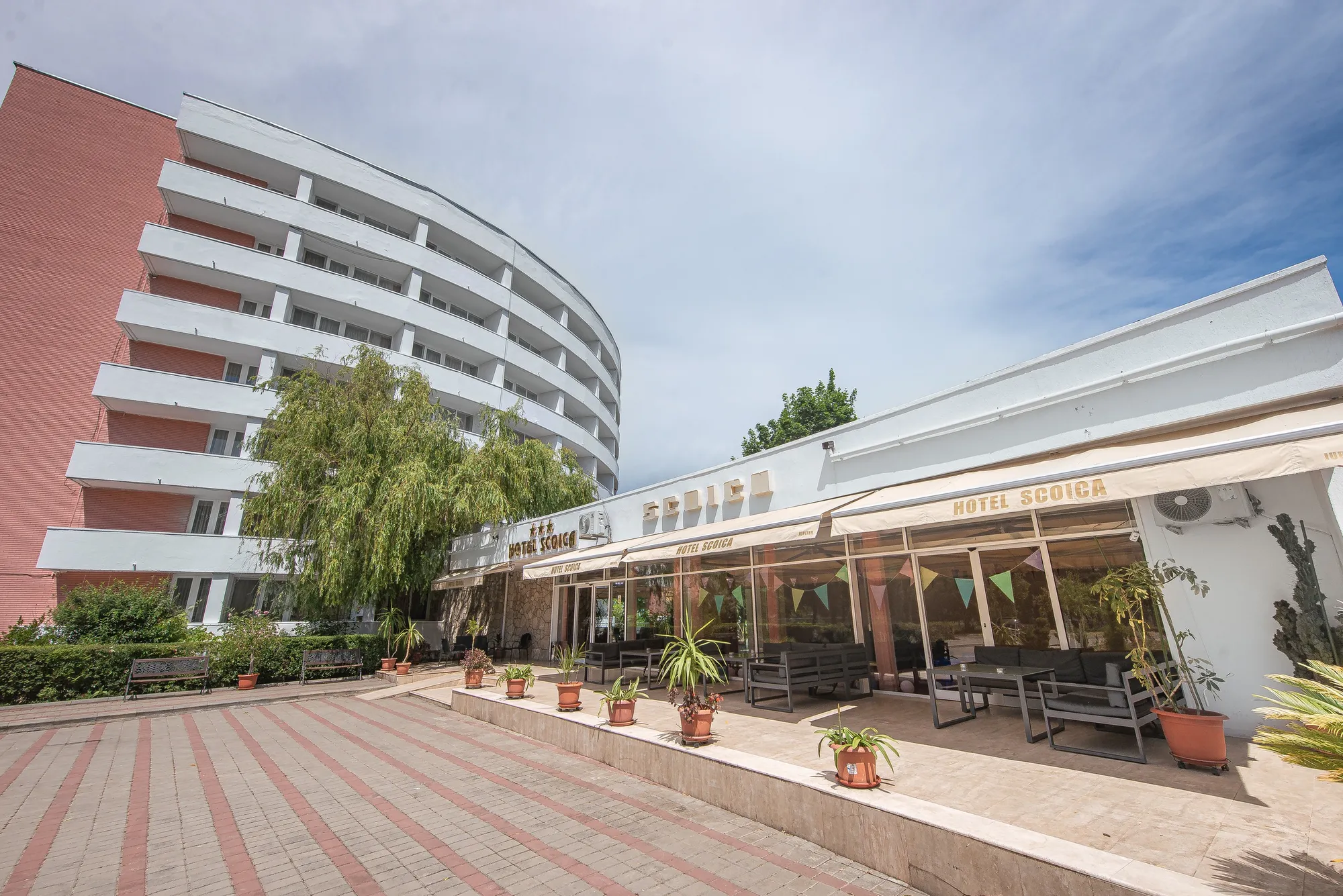 Fațada hotelului cu terasa restaurantului în prim-plan